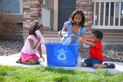 african-american-family-placing-bottles-in-blue-recycling-bin